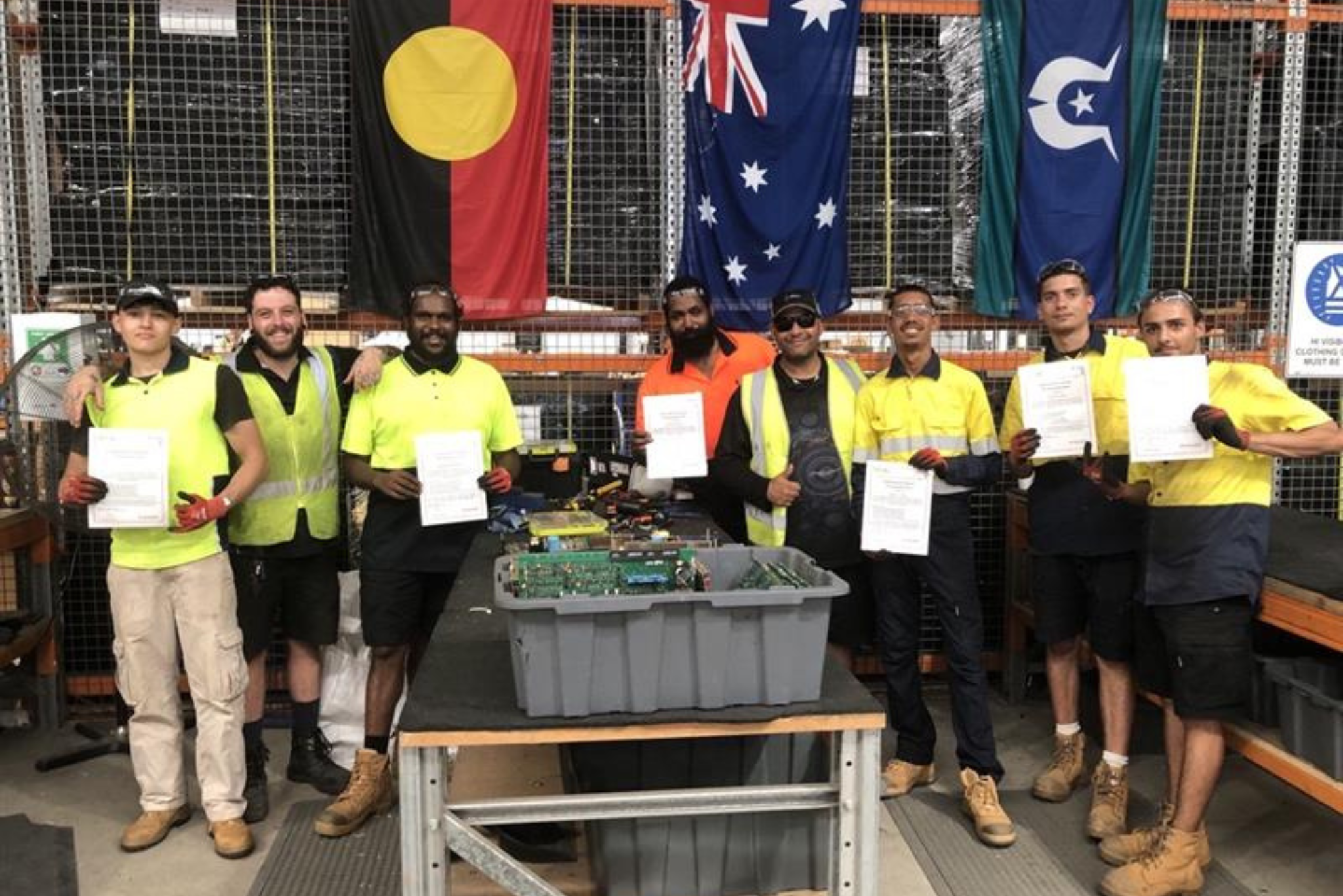Group of Breakthrough Course Graduates pose with their Graduation Certificates in the WV Technologies/Worldview Foundation Brendale warehouse.